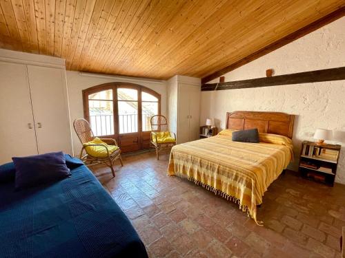BorredáApartamento rural con encanto Can Salvador的一间卧室设有两张床和木制天花板