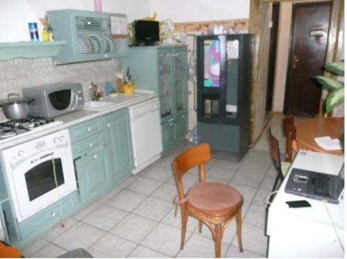 罗马walter guest house的厨房配有绿色橱柜和桌椅