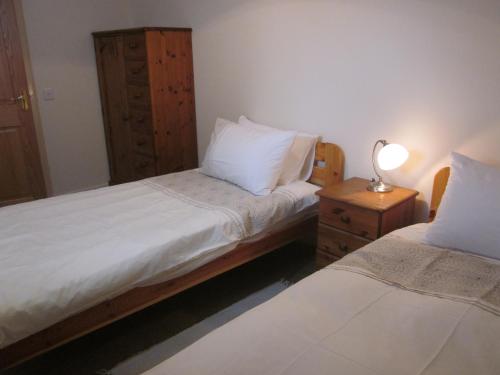 林利斯戈Easter Bowhouse Farm Cottage的一间卧室配有两张床和床头灯。