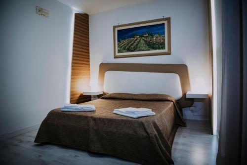 比亚恩卡维拉Hotel Casale dei Greci的一间卧室配有一张床,上面有两条毛巾