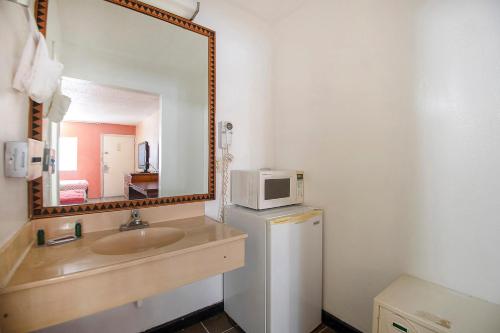 埃尔克哈特Hotel O Daylight Inn Elkhart I-90, IN的一间带水槽和镜子的浴室以及一台冰箱