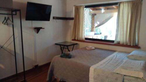 卡利亚里Tiny House的一间卧室配有一张床、一台电视和一个窗口