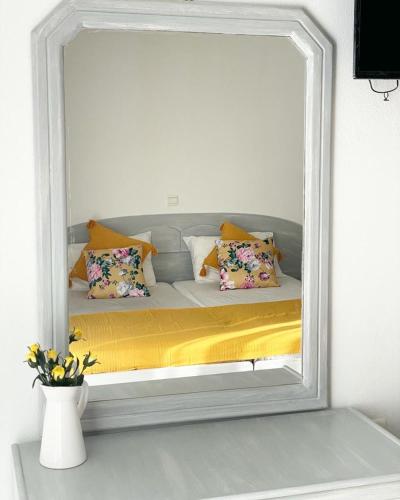 伊古迈尼察ALEKA KOTSI ROOMS 2的镜子反射着一张带枕头的床