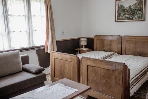 MagyarszombatfaIldikó Vendégház的一间卧室配有一张木床和一张沙发