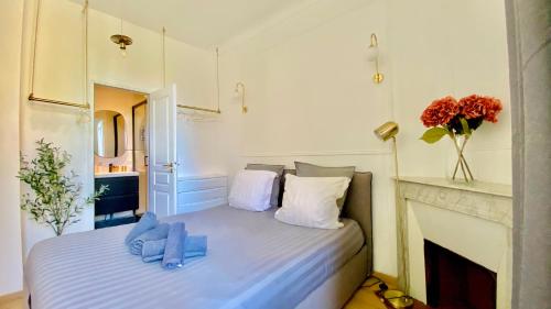 蒙特卡罗Designer Garden View AC, Fiber Wifi Heart of Monaco的一间卧室配有一张带蓝色毛巾的床