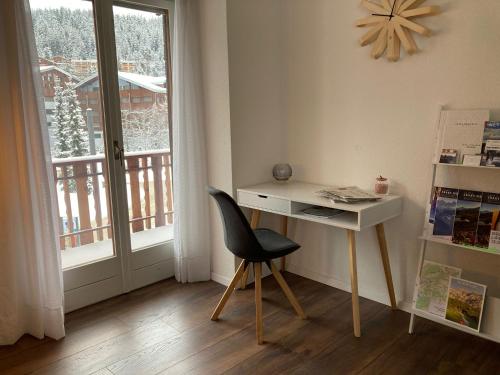 克莱恩 蒙塔纳Résidence Plambramois的窗户客房内的一张桌子和一把椅子