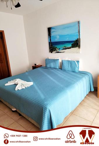 罗阿坦Sunset Waves的一间卧室配有一张蓝色的床,享有大海美景