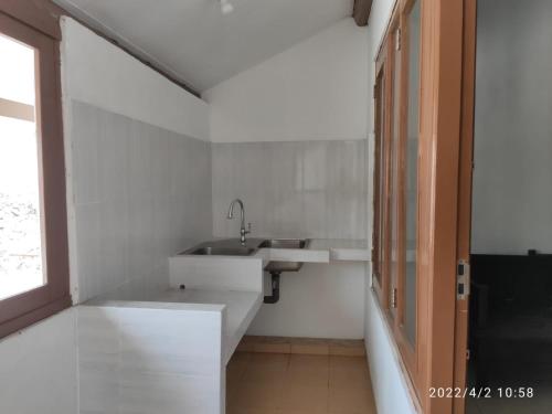 三宝垄Kelana 2 Nice Homestay (5 Bed Rooms) Semarang的白色的浴室设有水槽和窗户。