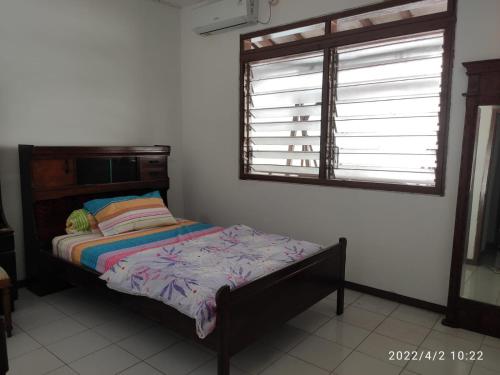 三宝垄Kelana 2 Nice Homestay (5 Bed Rooms) Semarang的一间卧室设有一张床和一个窗口