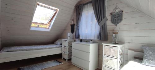 ZachełmieDomek w Karkonoszach的一间卧室设有两张床和窗户。