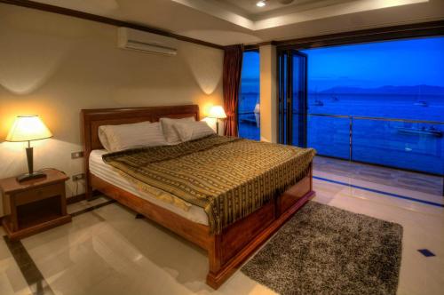 苏梅岛Emerald Beach-Front Apartments Fishermans Village的一间卧室设有一张床,享有海景