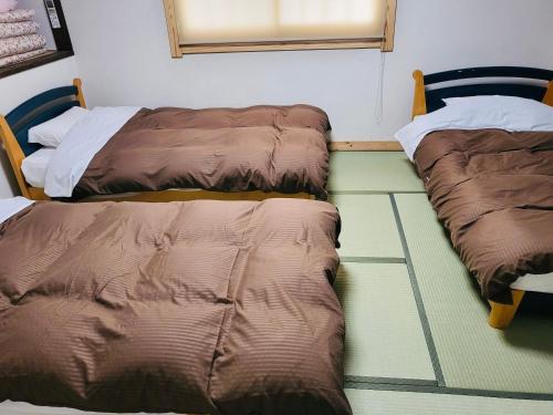 白马村Hakuba Inn Bloom的两张睡床彼此相邻,位于一个房间里