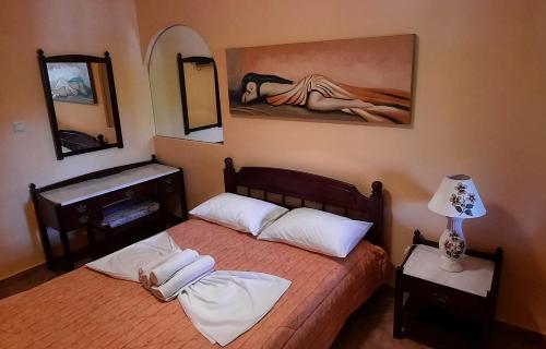 EpanochoriPorofarago的一间卧室设有两张床,墙上挂着一幅画