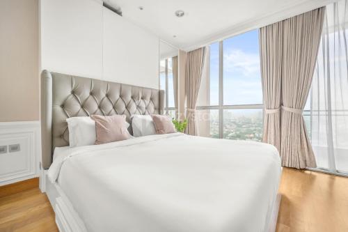 雅加达Blanc by Kozystay - SCBD的卧室设有一张大白色的床和大窗户