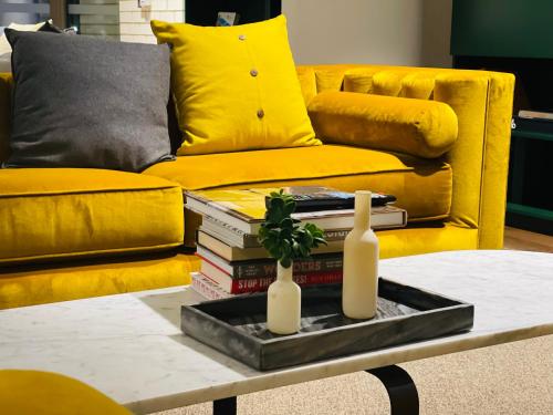 墨尔本PoolGymconference Room Executive living Great Location的客厅设有黄色的沙发和带书籍的桌子