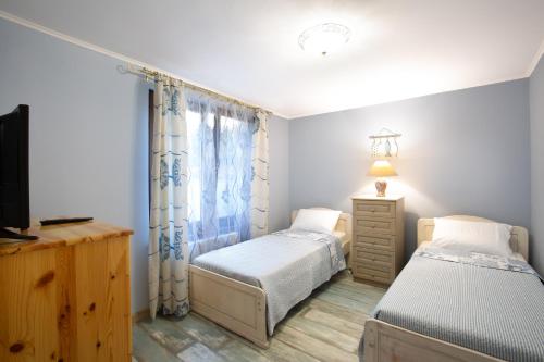 内塞伯尔Guest House Soirée的一间卧室配有两张单人床和一台电视机