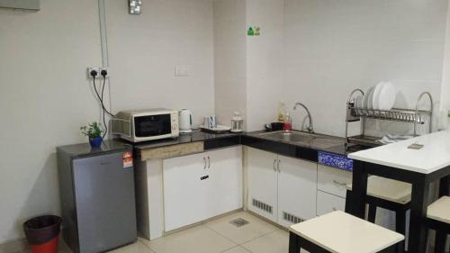 哥打巴鲁Staycity Apartment - D'Perdana Sri Cemerlang的厨房配有水槽和台面上的微波炉