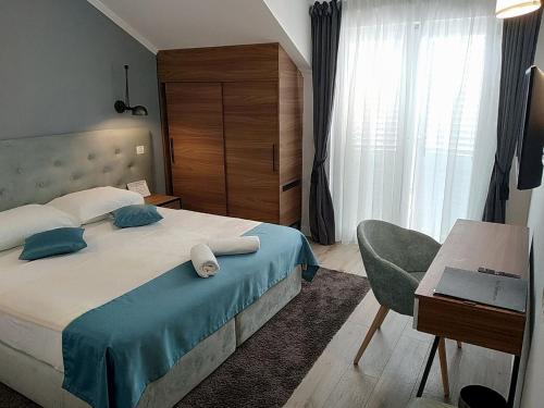 杜布罗夫尼克珀尔塔酒店的一间卧室配有一张带桌子和椅子的床