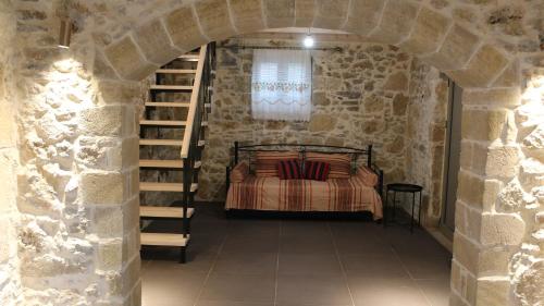AïkiryiánnisMouri Village的卧室配有一张石墙床