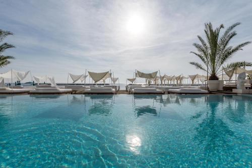 丽都迪萨维奥维士塔梅赫套房酒店的一个带躺椅的大型游泳池,棕榈树