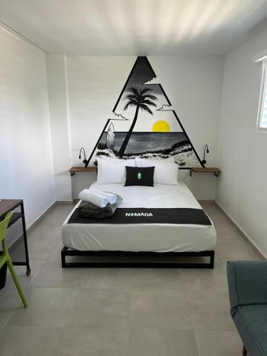 圣胡安Nomada Beach Hostel- Isla Verde的卧室配有一张带棕榈树壁画的床。