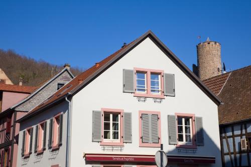 凯泽贝尔Chambres Chez Laurence的街上有粉红色百叶窗的白色房子