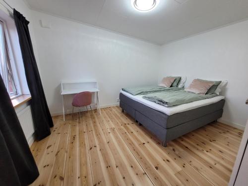 ÅsaVilla Lotta的一间卧室配有一张床,铺有木地板