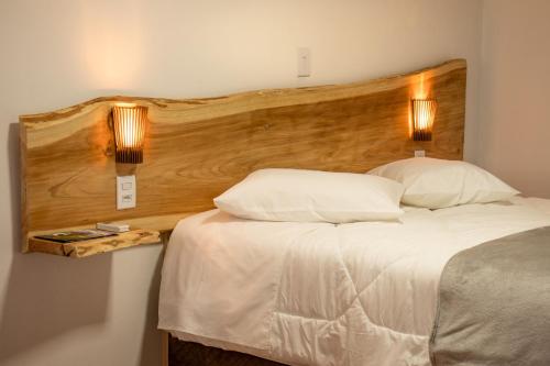 坎巴拉Refúgio Fortal的一间卧室配有一张大床和木制床头板