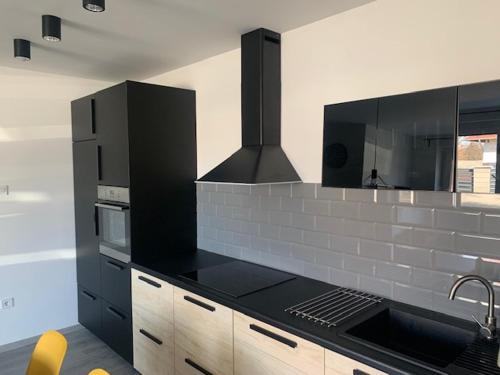 格德勒New Home Guest House的厨房配有黑色柜台和炉灶。 顶部烤箱