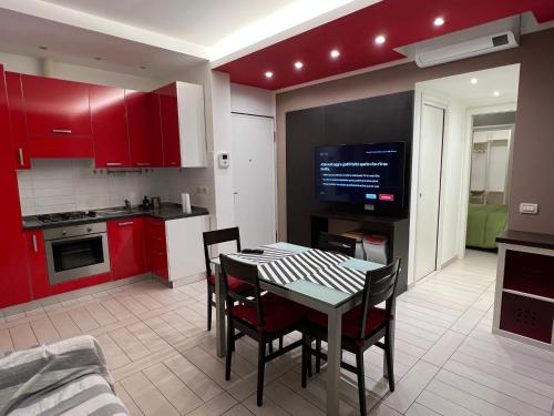 安科纳Al Piano 2的厨房配有红色橱柜和桌椅
