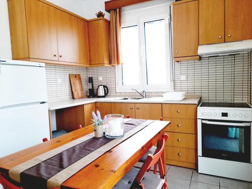卡利塞亚-豪客迪克斯Kallithea Central Residence的厨房配有木制橱柜和木桌。