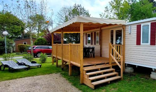 ClaoueyMobil Home Camping Les VIVIERS, Claouey的小木屋设有门廊和甲板