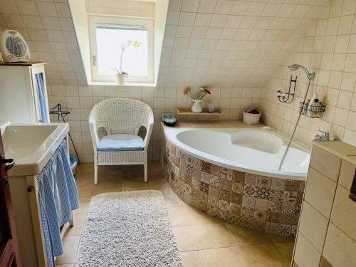 巴拉顿凯奈谢5 bedroom villa very close to Balaton的带浴缸、椅子和窗户的浴室
