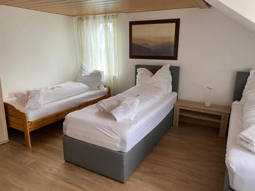 锡根Dorfschenke的配有2张床的带白色床单和枕头的客房