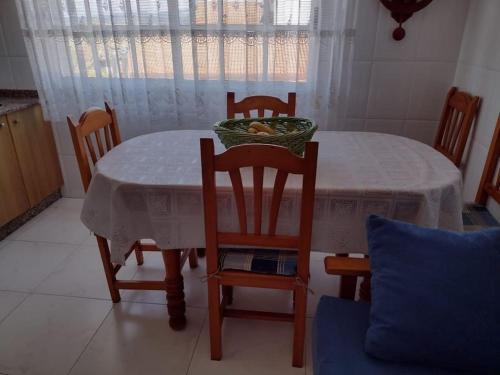 格罗韦Apartamento en San Vicente de O Grove的餐桌,椅子和碗