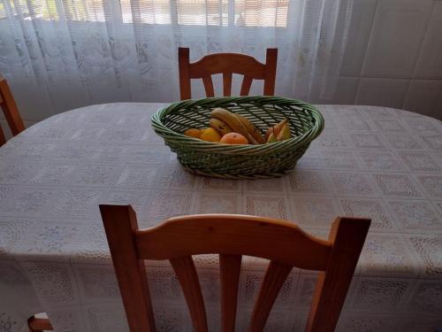 格罗韦Apartamento en San Vicente de O Grove的坐在桌子上一篮水果