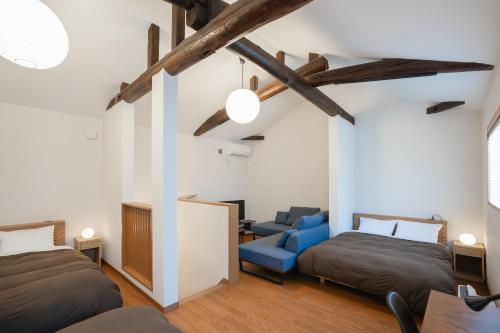 宫津市Coto的一间卧室配有两张床和一张蓝色椅子