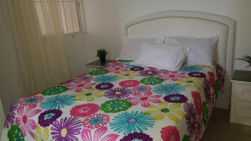 苏莎亚Fully Equipped New 2br Apt–dt–2mins To The Beach的一张带色彩缤纷的被子和枕头的床