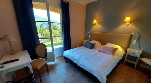 Mourèze莱斯豪特斯莫雷兹酒店的一间卧室设有一张床和一个大窗户
