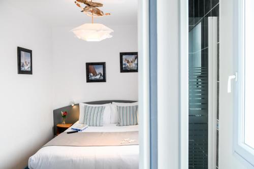 米尼赞海滩Logis Hotel de France的卧室配有滑动玻璃门旁边的床