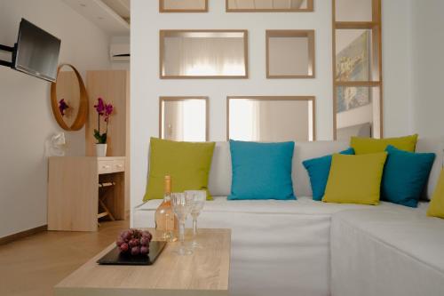纳克索乔拉Polis of Naxos Boutique Hotel的客厅配有白色沙发,提供蓝色和绿色枕头