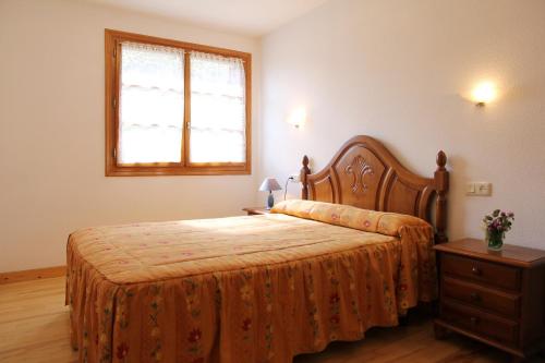 贝纳斯克Apartamentos Los Tilos的一间卧室配有一张床、一个梳妆台和一扇窗户。