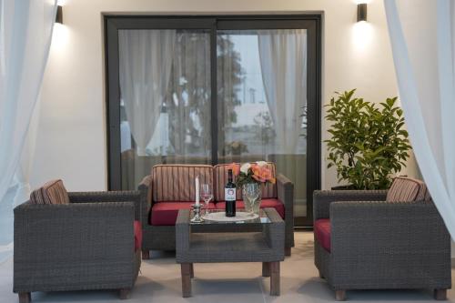 佩里沃罗Villa Basilica Kalavria的客厅配有两把椅子和一张桌子及一瓶葡萄酒