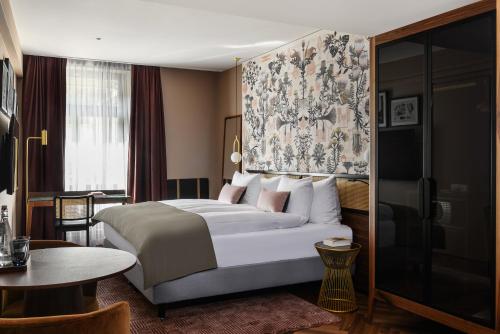 苏黎世Boutique Hotel Seidenhof的酒店客房设有一张大床和一张桌子。