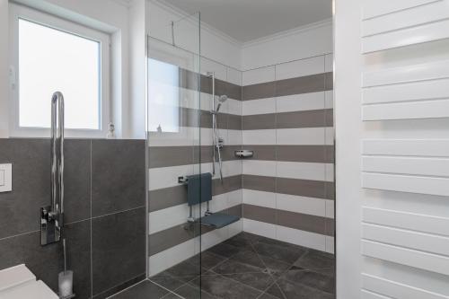 奥斯赛拜-屈隆斯博恩Westside Arthotel的带淋浴的浴室和玻璃门