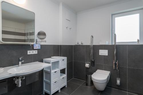 奥斯赛拜-屈隆斯博恩Westside Arthotel的一间带水槽、卫生间和镜子的浴室