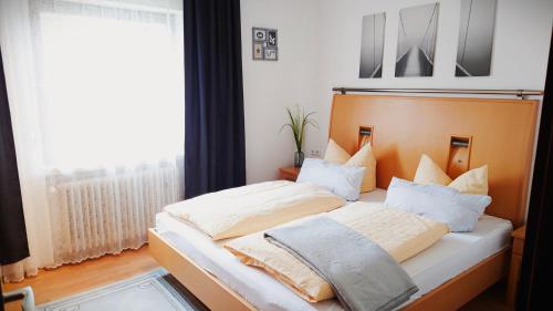 赫尔-格伦茨豪森Hotel Garni Zur Traube的一间卧室配有一张带床头板的床和窗户