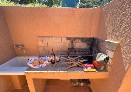 帕拉迪索海岸Veranda sul Paradiso的户外烧烤,包括一瓶葡萄酒和酒精