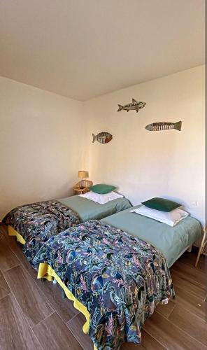卡尔热斯Appartement Vue mer en plein centre de Cargese的墙上有鱼的房间,设有两张床
