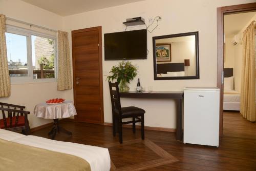 耶路撒冷里哈维亚小屋酒店的酒店客房设有带书桌和电视的卧室。